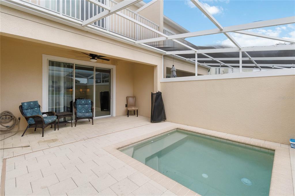 A small rectangular pool sits on a paved patio beneath a screened-in lanai — 17416 PLACIDITY AVENUE, CLERMONT, FL