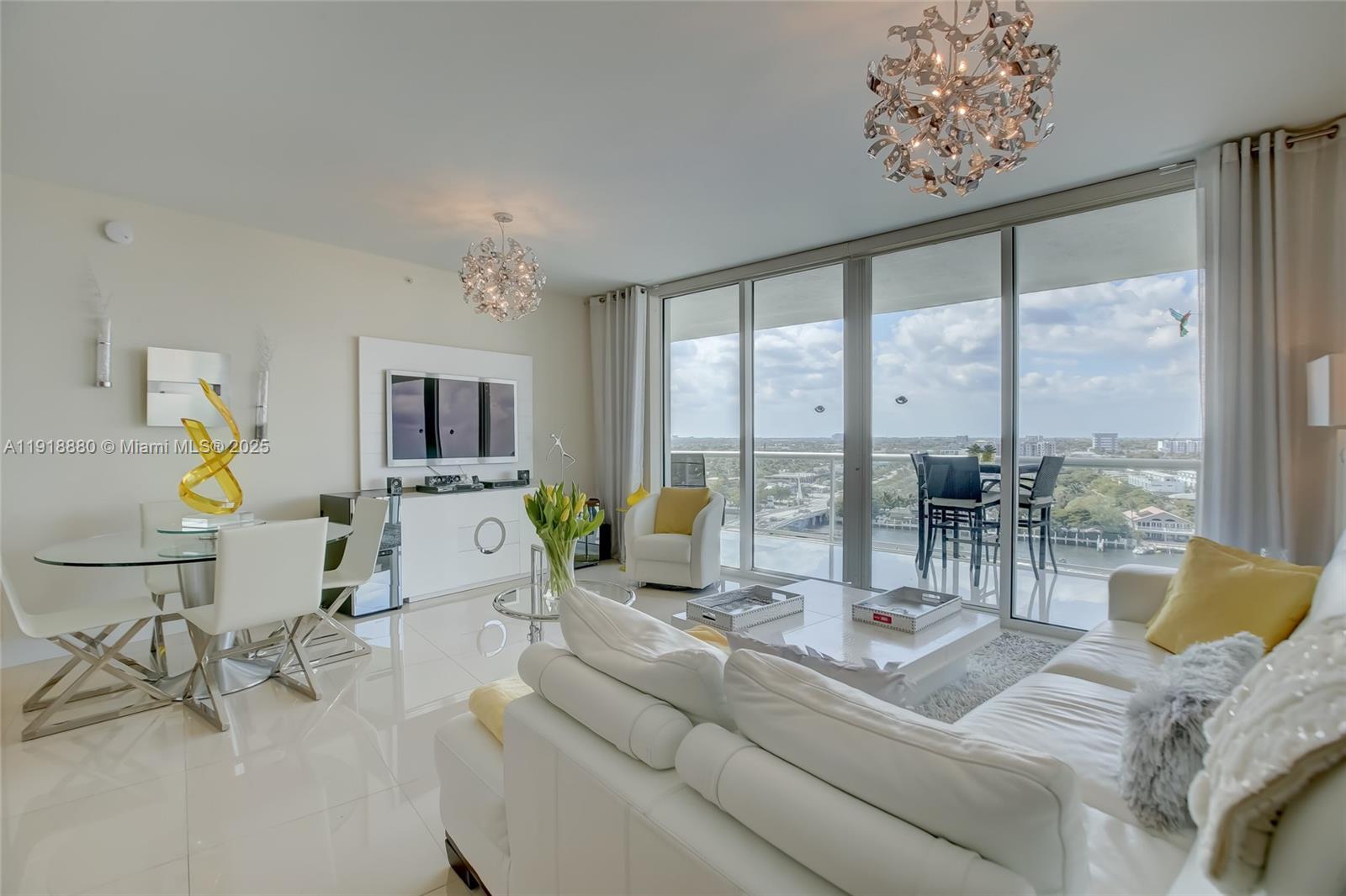 A bright living and dining area features white furniture, tile floors, and floor-to-ceiling balcony windows — 1 N Ocean Blvd # 1011, Pompano Beach FL 33062, POMPANO BEACH, FL