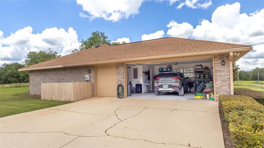 An open-concept kitchen and living area features wood flooring, light-colored cabinets, and pendant lighting — 4660 SE 3RD PLACE, KEYSTONE HEIGHTS, FL