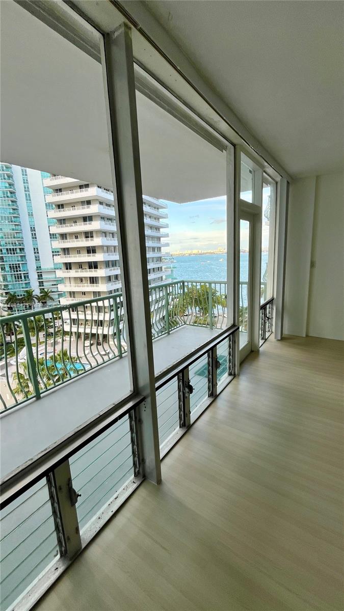 An interior room features floor-to-ceiling windows and a balcony overlooking the ocean and buildings — 1408 Brickell Bay Dr # 916, Miami FL 33131, MIAMI, FL