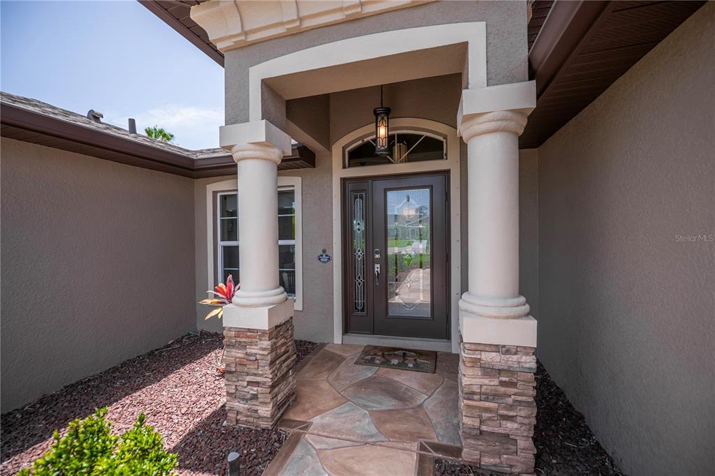 A front entryway features a glass-paneled door flanked by two stone-based columns — 419 BAHIA GRANDE AVENUE, PUNTA GORDA, FL