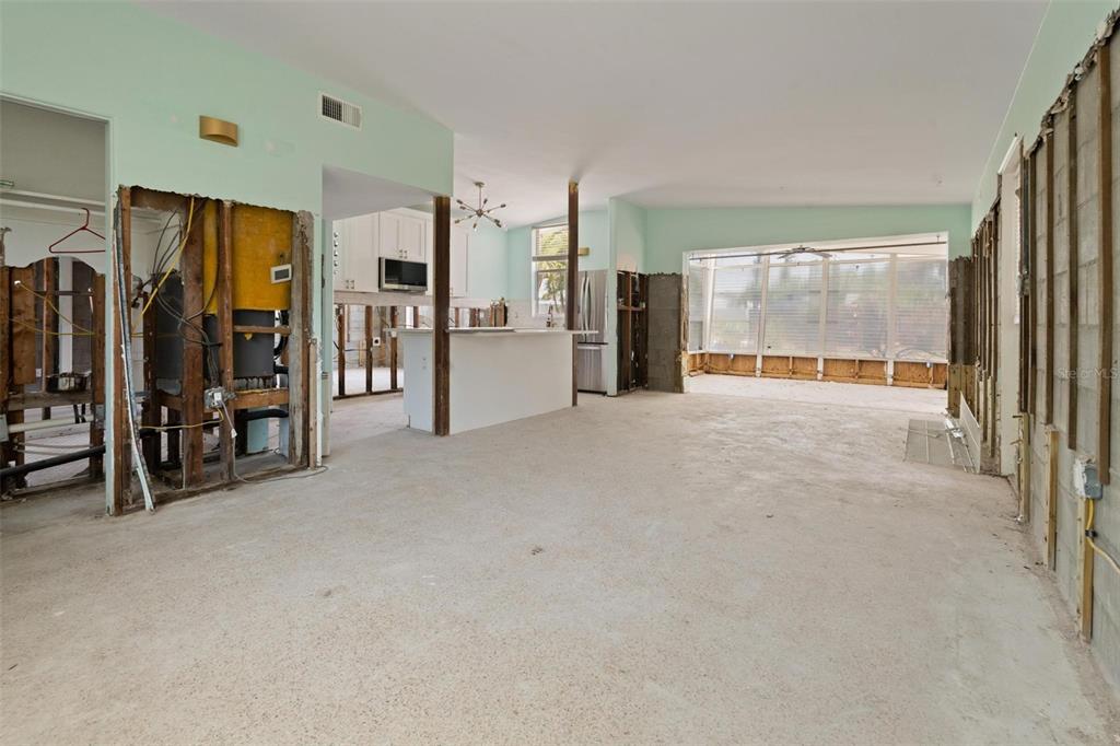 An interior view of a room under construction with exposed wall studs and concrete floors — 3727 ALABAMA AVENUE NE, ST PETERSBURG, FL