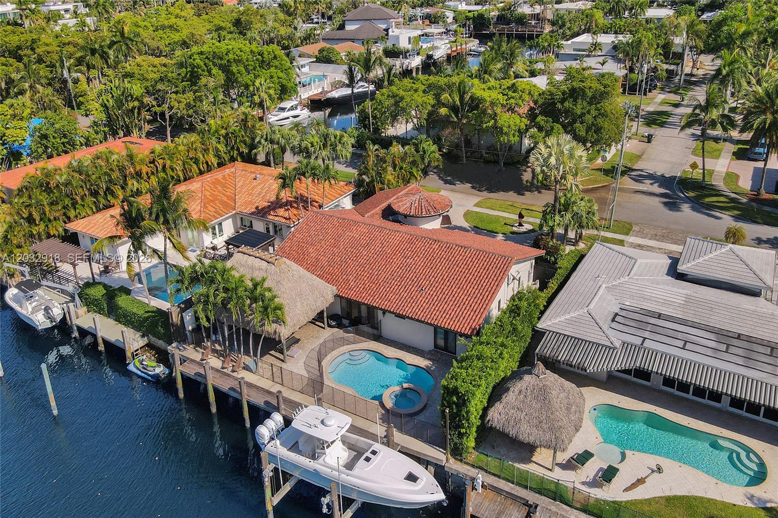 An aerial view shows waterfront homes with swimming pools, boat docks, and thatched-roof gazebos — 2075 Ixora Rd # 0, North Miami FL 33181, NORTH MIAMI, FL