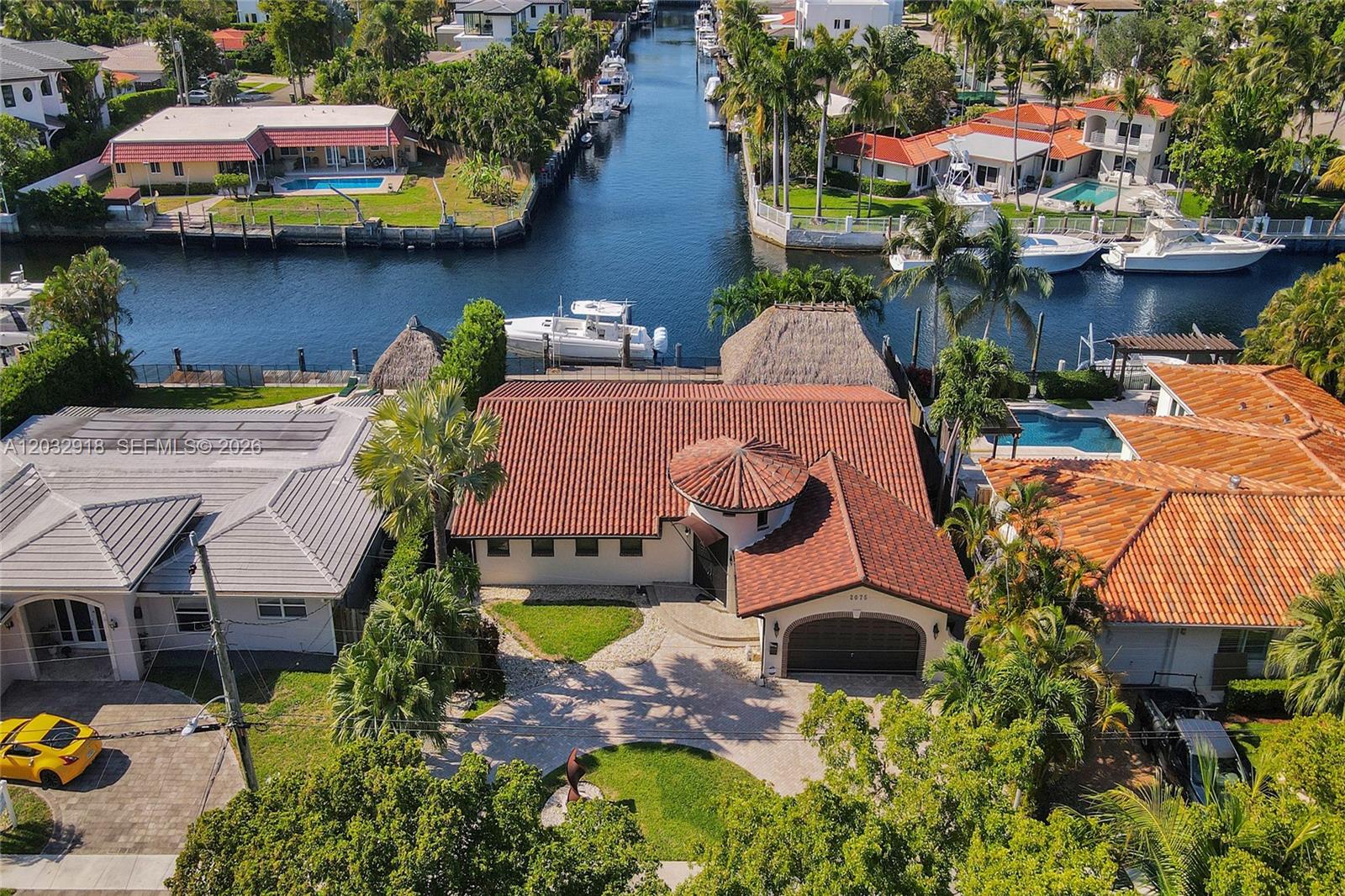 An aerial view shows a waterfront house with a tiled roof, pool, and boat dock — 2075 Ixora Rd # 0, North Miami FL 33181, NORTH MIAMI, FL