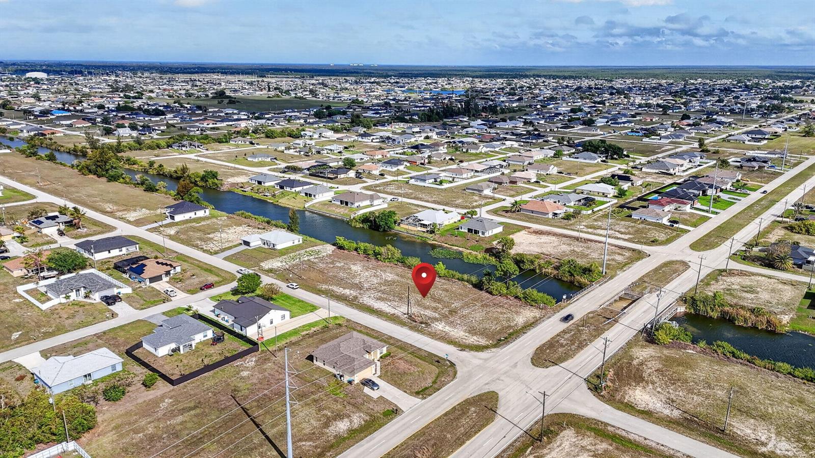 An aerial view shows a vacant residential lot marked by a red pin near a canal — 5 NW 19th Terrace, Cape Coral FL 33993, CAPE CORAL, FL