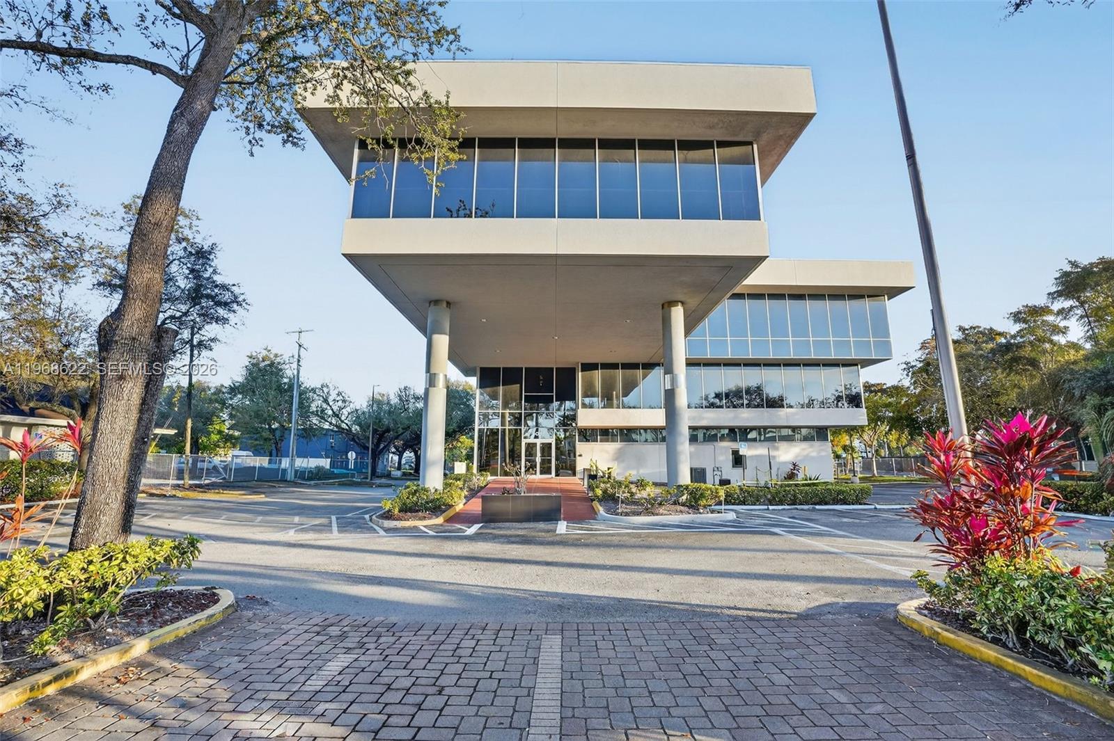 A modern office building features a cantilevered upper level supported by two large concrete pillars — 6067 Hollywood Blvd, Hollywood FL 33024, HOLLYWOOD, FL