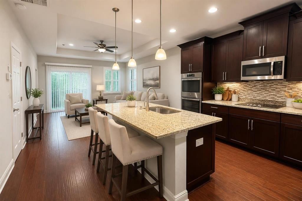 A living room features two beige sofas, a glass coffee table, and dark wood flooring — 1747 OAK HAMMOCK COURT, LUTZ, FL