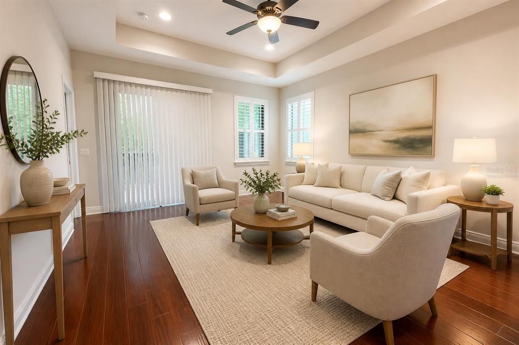 A living room features a dark media console, a light sofa, and a glass coffee table — 1747 OAK HAMMOCK COURT, LUTZ, FL