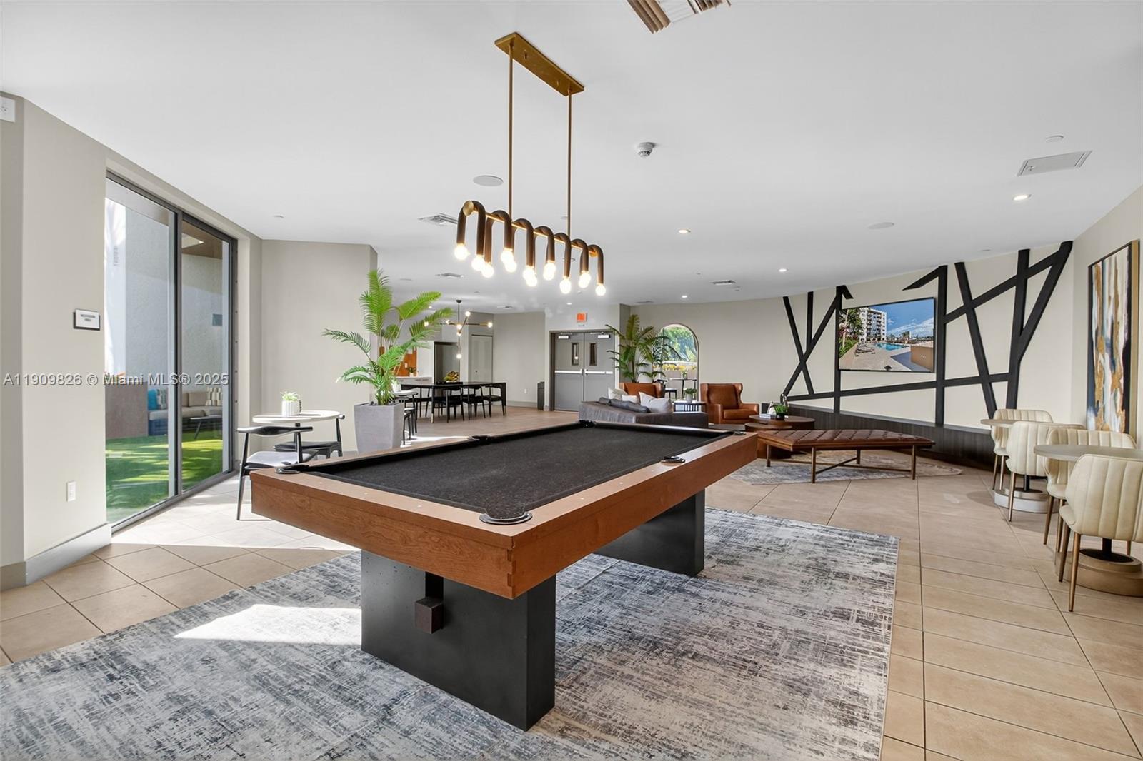 A spacious lounge area features a pool table, modern lighting, and contemporary seating arrangements — 1110 NW 1 ST # 502, Miami FL 33128, MIAMI, FL