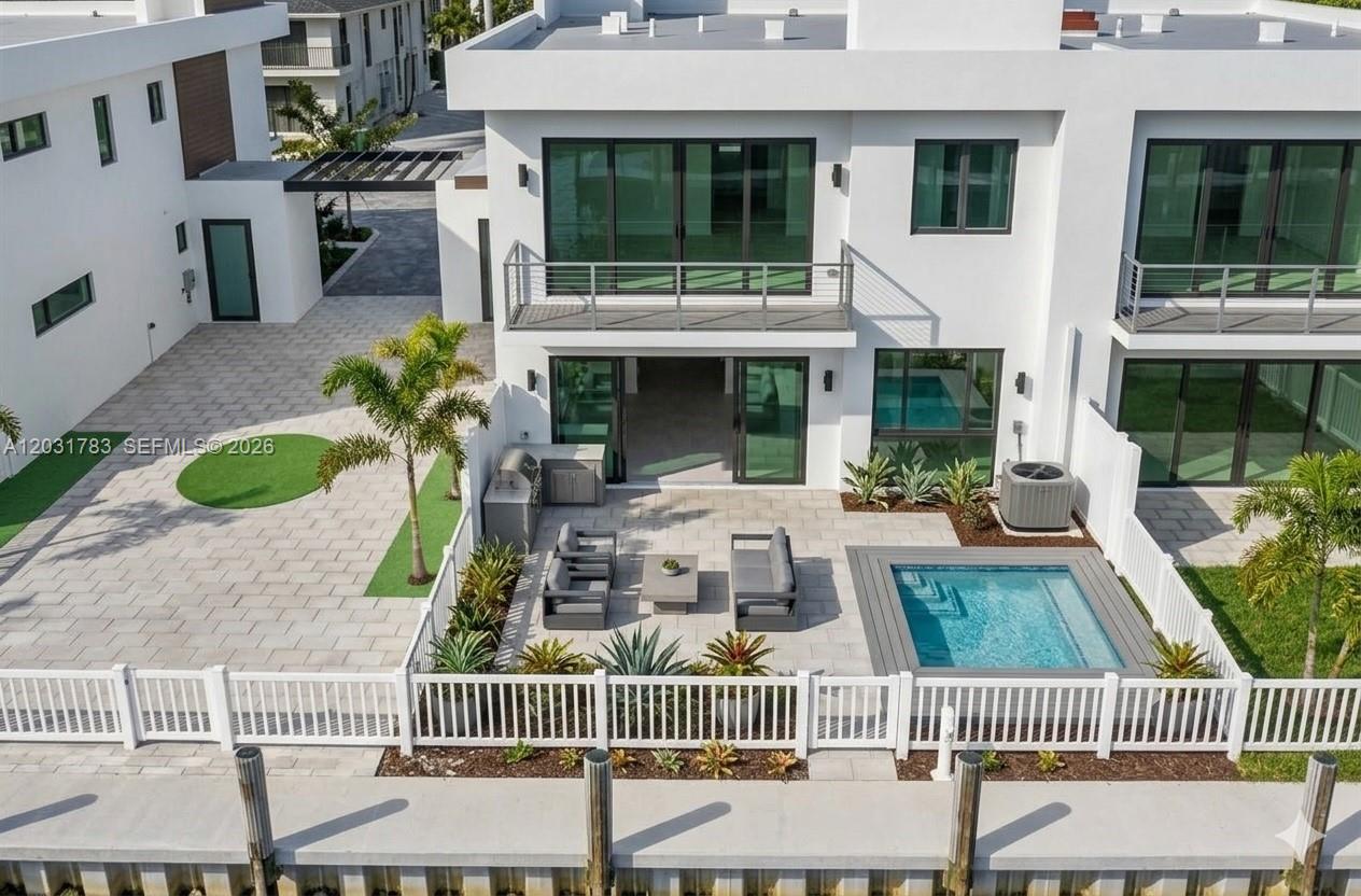 An aerial view of a modern white house with a patio, pool, and boat dock — 4636 SW 32nd Ave # C2, Dania Beach FL 33312, DANIA BEACH, FL