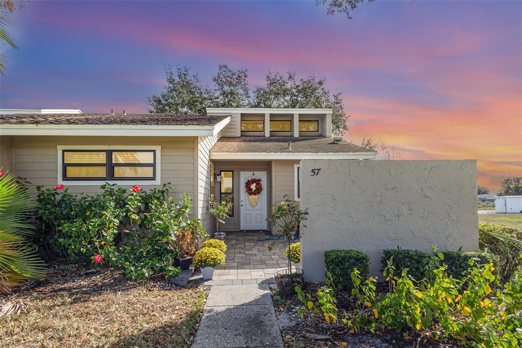 A single-story house with a beige exterior, a paved walkway, and a front door with a wreath — 5225 IMPERIAL LAKES BOULEVARD UNIT 57, MULBERRY, FL