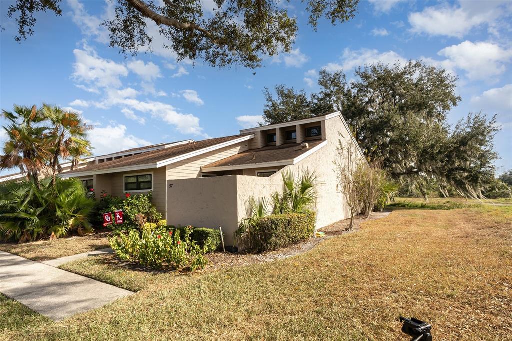 A tan, single-story townhouse with a shed roof and a small private courtyard — 5225 IMPERIAL LAKES BOULEVARD UNIT 57, MULBERRY, FL
