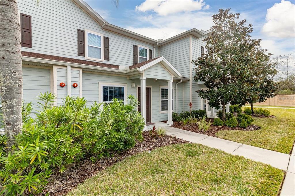A two-story light blue house with dark shutters and a covered front entryway — 3203 OYSTER LANE, KISSIMMEE, FL