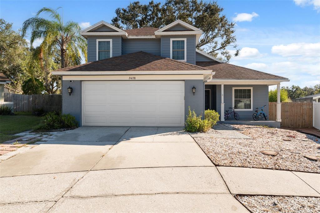 A two-story blue house with a two-car garage and a concrete driveway — 24138 TWIN COURT, LAND O LAKES, FL