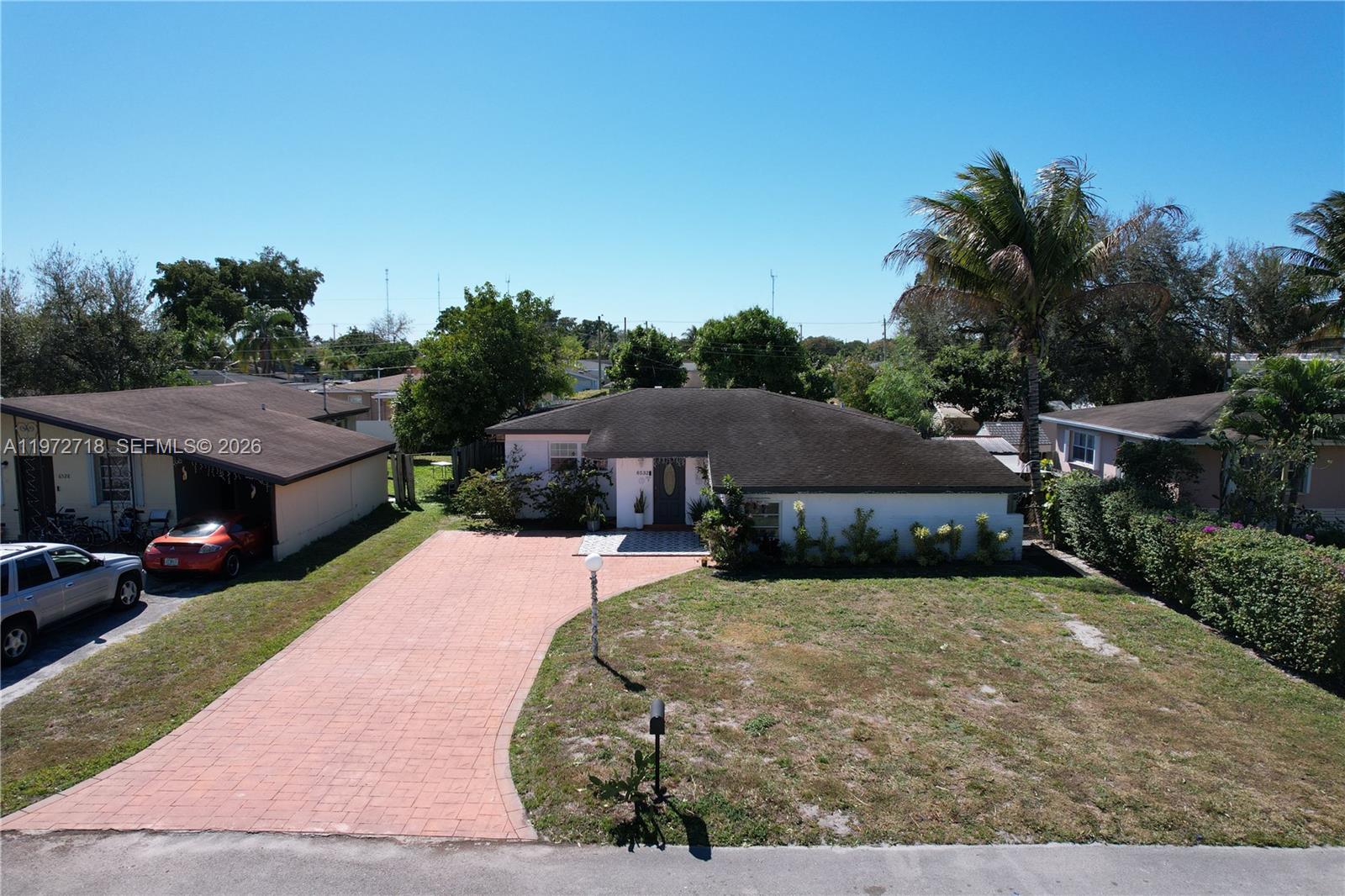 An aerial view shows a single-story house with a paved driveway and a front lawn — 6532 Mayo St, Hollywood FL 33023, HOLLYWOOD, FL