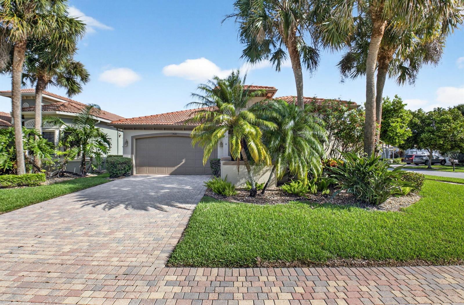 A single-story house with a tiled roof, a paved driveway, and palm trees in front — 9571 Isles Cay Drive, Delray Beach FL 33446, DELRAY BEACH, FL