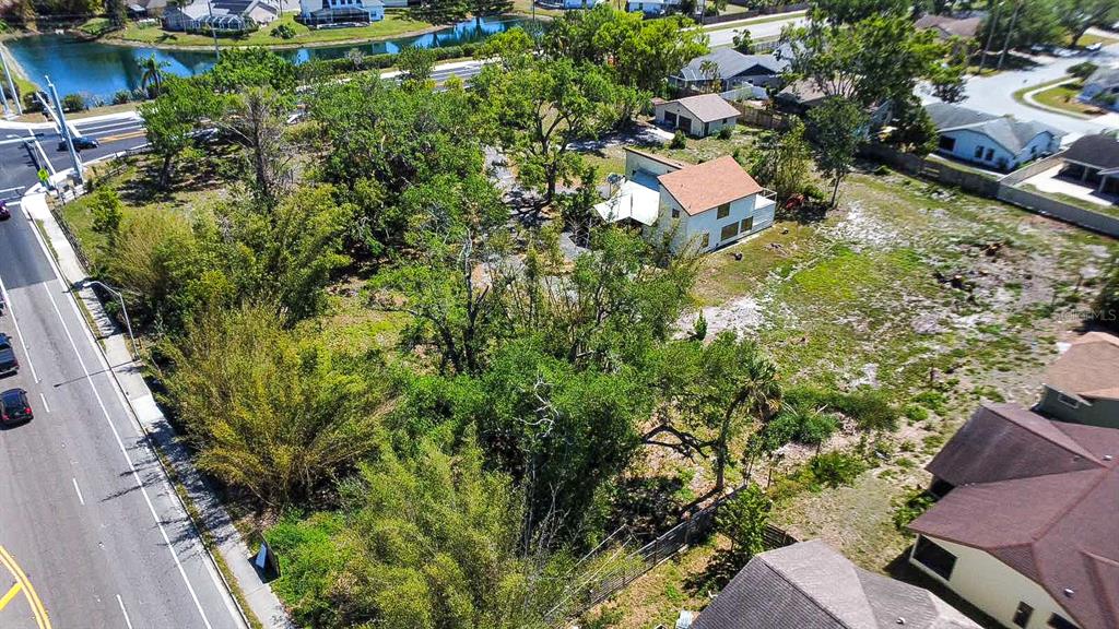 An aerial view shows a residential lot with a house, trees, and adjacent road — 7720 TUTTLE AVENUE, SARASOTA, FL