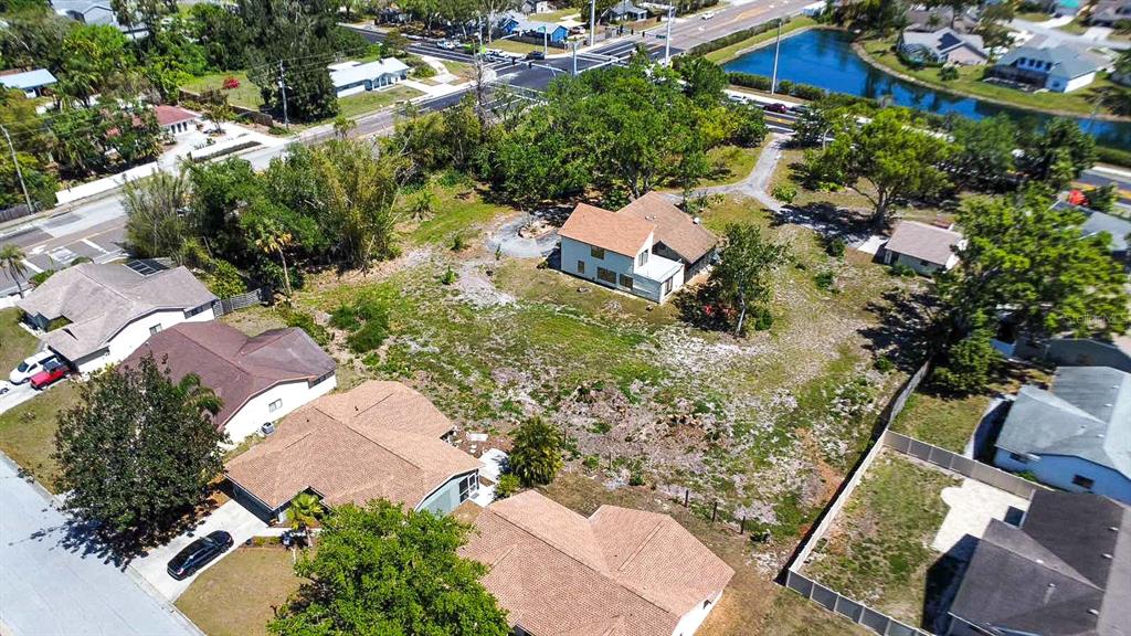 An aerial view shows a residential lot with a house surrounded by trees and roads — 7720 TUTTLE AVENUE, SARASOTA, FL