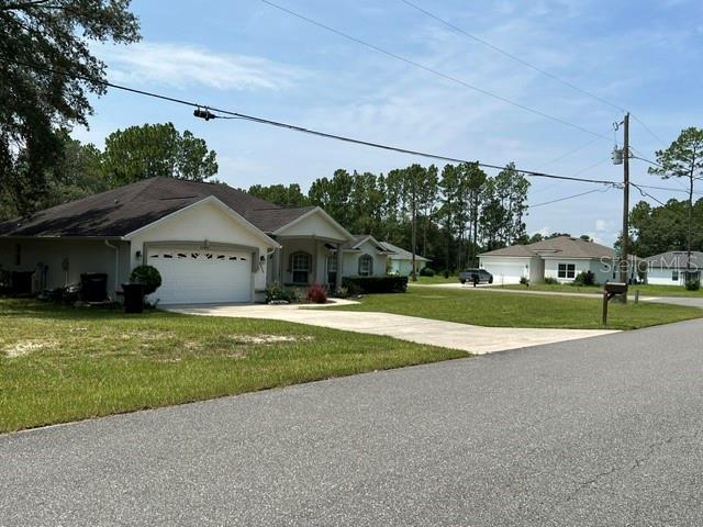 A single-story house with a white garage and driveway sits on a grassy suburban lot — Lot 2 SW 132 STREET, OCALA, FL