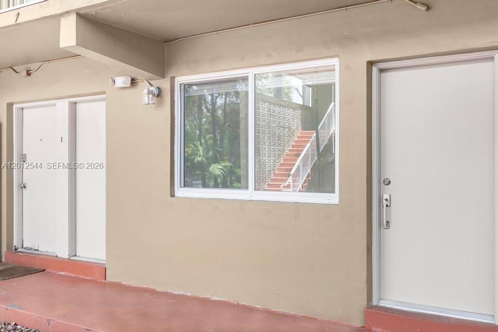 An exterior view shows two white doors flanking a large window with a staircase visible — 6330 SW 79th St # 2, South Miami FL 33143, SOUTH MIAMI, FL