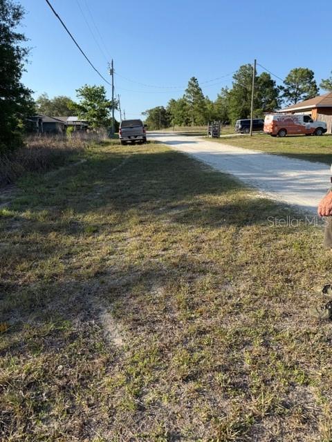 A dirt road leads past a parked pickup truck and a van in a rural area — SW 142 COURT, OCALA, FL