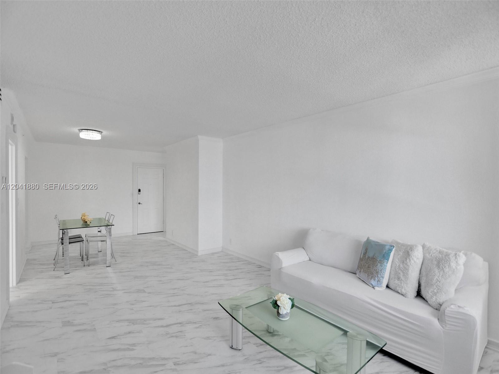A living and dining area features white walls, light marble-patterned flooring, and modern glass furniture — 2501 S Ocean Dr, Hollywood FL 33019, HOLLYWOOD, FL