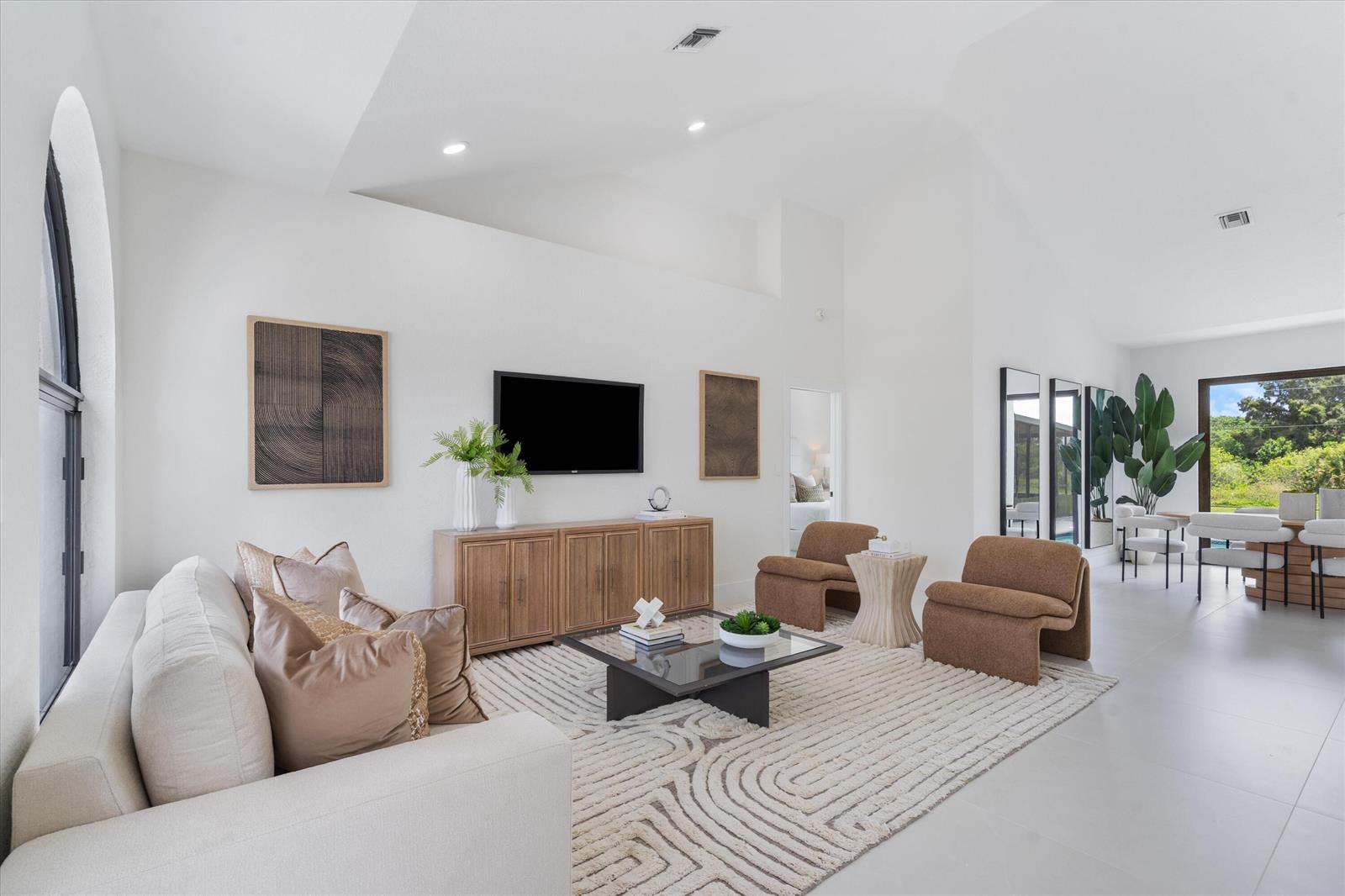 A bright living room features a white sofa, wood console, and two brown armchairs — 7548 Fairway Trail, Boca Raton FL 33487, BOCA RATON, FL
