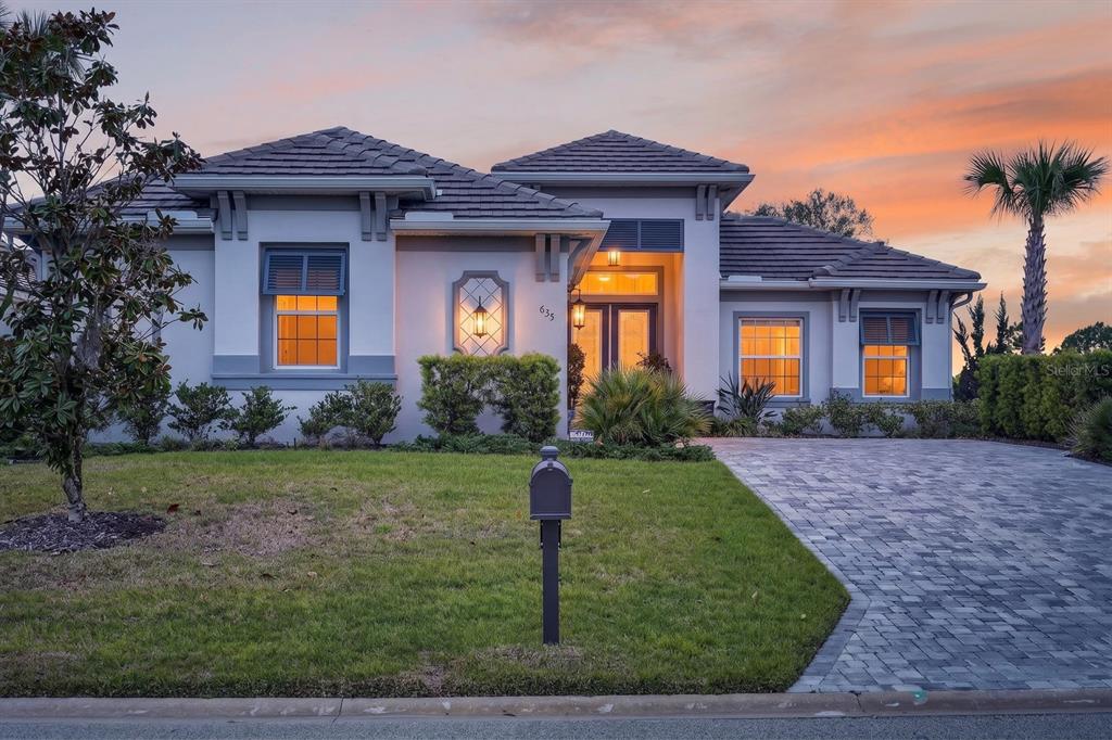A single-story house with a paved driveway, a mailbox, and a landscaped front yard — 635 MAHOGANY RUN, PALM COAST, FL