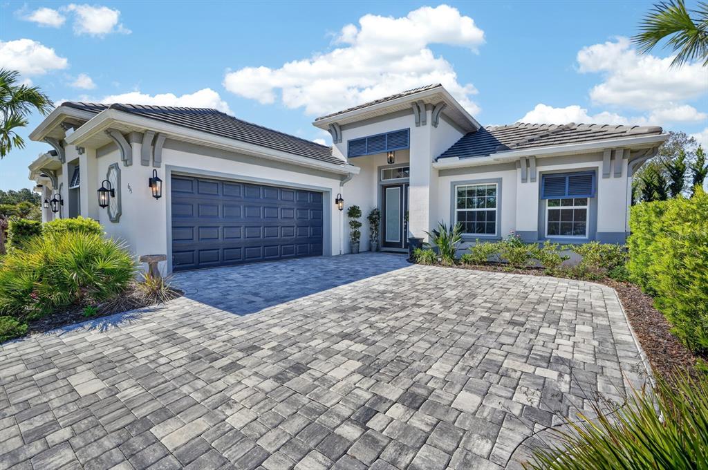 A single-story house with a paved driveway, dark garage door, and light-colored stucco exterior — 635 MAHOGANY RUN, PALM COAST, FL
