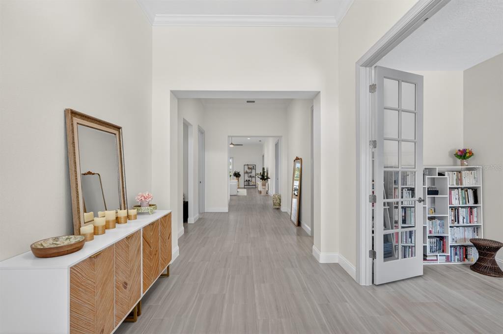 A bright hallway with light wood-look flooring leads to an open living area — 635 MAHOGANY RUN, PALM COAST, FL