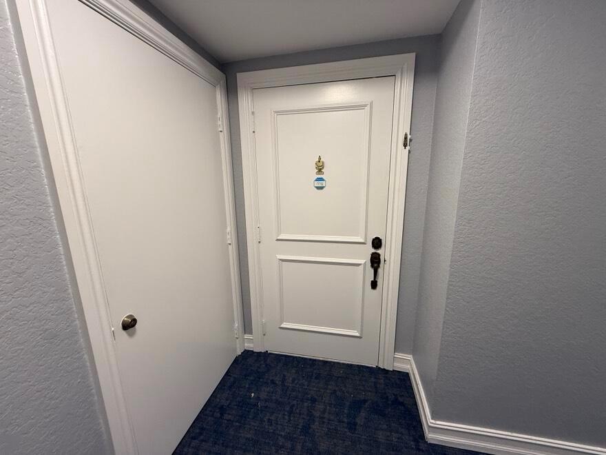 A white door with a doorbell camera and a adjacent closet door in a hallway — 7847 Lakeside Boulevard # 1024, Boca Raton FL 33434, BOCA RATON, FL