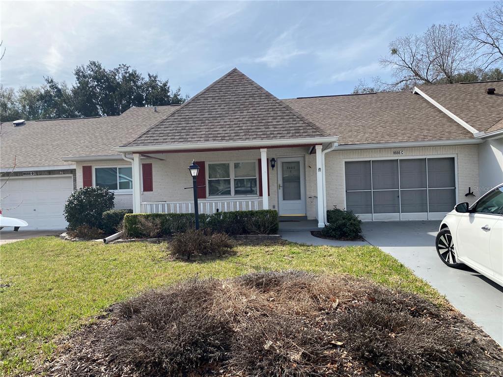A single-story brick house with a front porch, a garage, and a driveway — 8666 SW 92ND LANE UNIT C, OCALA, FL