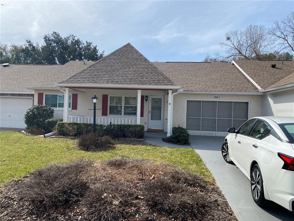 A single-story brick house with a gabled roof and a white car parked in front — 8666 SW 92ND LANE UNIT C, OCALA, FL