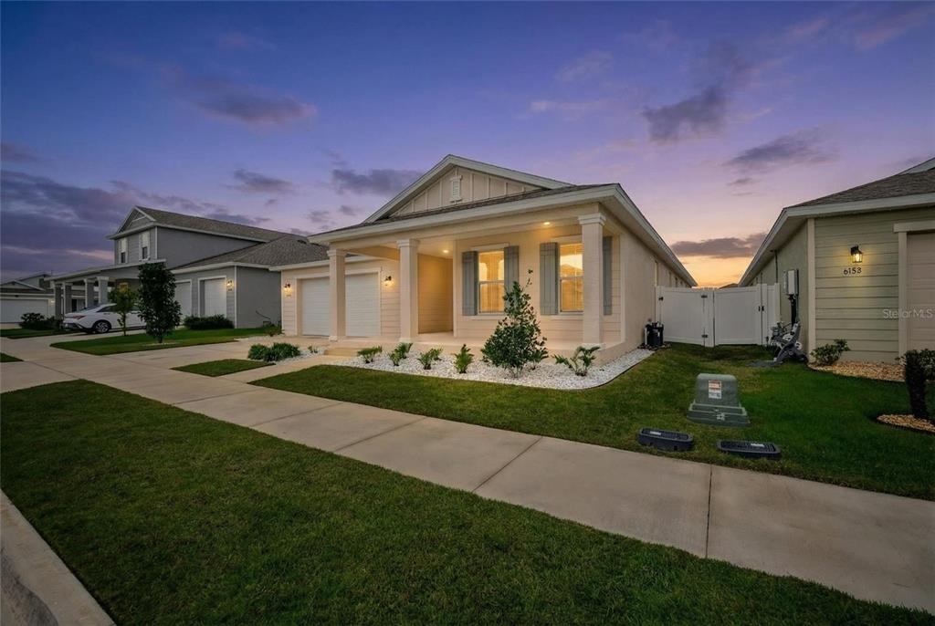 A single-story house with a covered front porch, white garage doors, and a landscaped yard — 6200 SW 72ND TERRACE, OCALA, FL