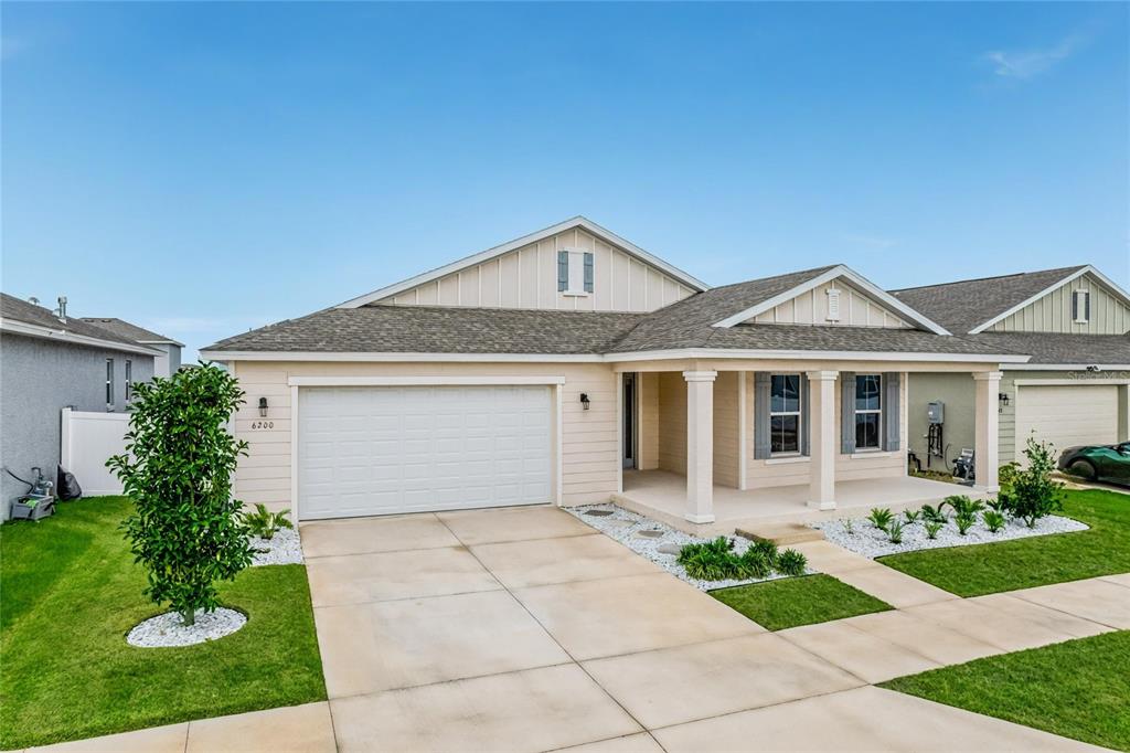 A single-story house with beige siding, a two-car garage, and a covered front porch — 6200 SW 72ND TERRACE, OCALA, FL