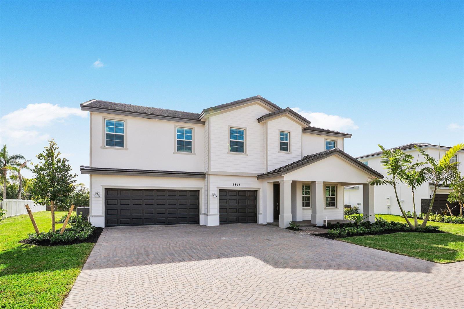 A two-story house with a white exterior, dark garage doors, and a paved driveway — 6843 Cobia Circle, Boynton Beach FL 33437, BOYNTON BEACH, FL