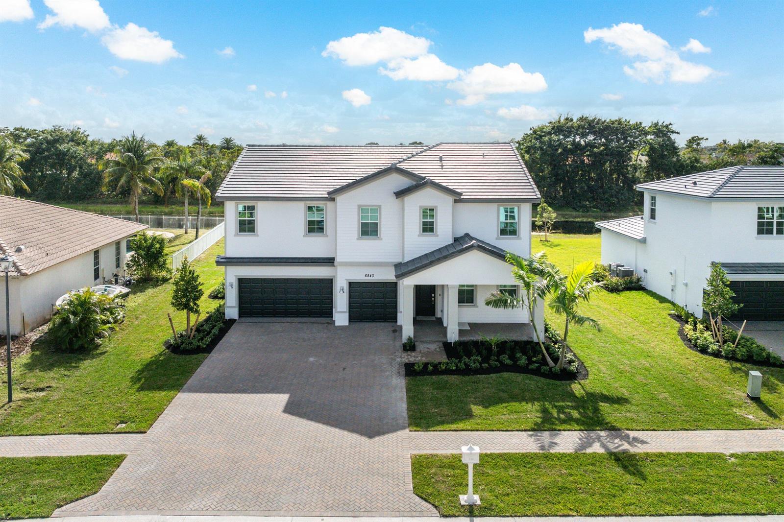 An aerial view of a two-story suburban house with a paved driveway and green lawn — 6843 Cobia Circle, Boynton Beach FL 33437, BOYNTON BEACH, FL