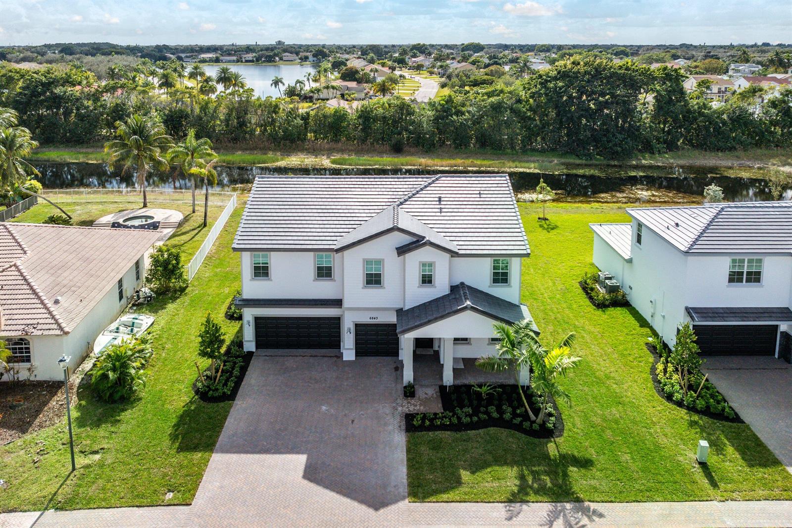An aerial view shows a two-story house with a tiled roof and a paved driveway — 6843 Cobia Circle, Boynton Beach FL 33437, BOYNTON BEACH, FL