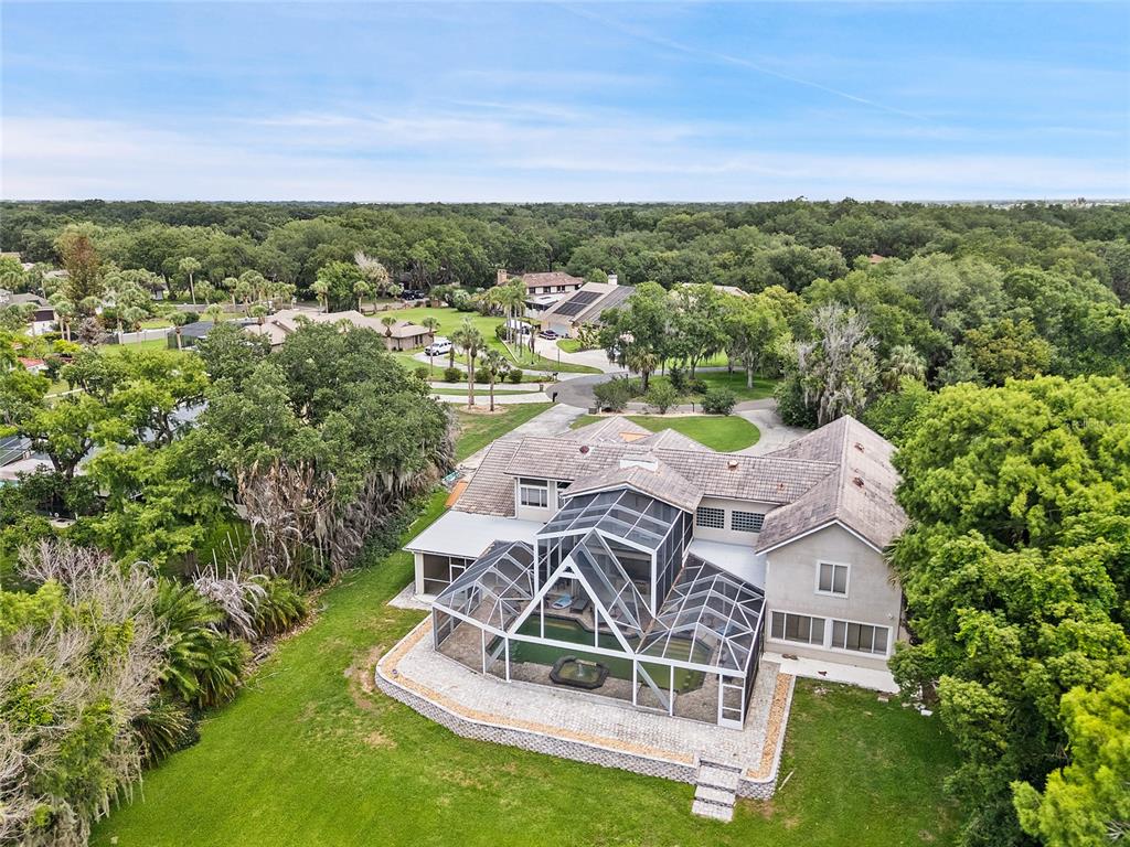 An aerial view of a two-story house with a large screened-in pool enclosure — 1890 SAHA COURT, KISSIMMEE, FL