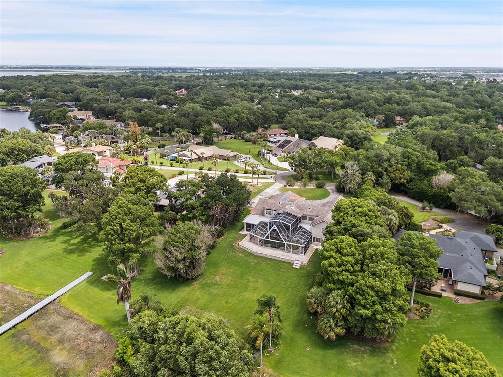 An aerial view shows a large house with a screened pool enclosure and expansive lawn — 1890 SAHA COURT, KISSIMMEE, FL
