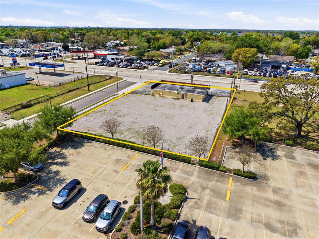 An aerial view shows a fenced, vacant lot with a small building and parking area — 1919 S ORANGE BLOSSOM TRAIL, ORLANDO, FL