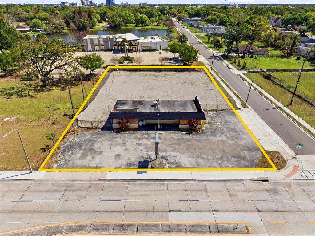 An aerial view shows a vacant commercial building on a paved lot outlined in yellow — 1919 S ORANGE BLOSSOM TRAIL, ORLANDO, FL