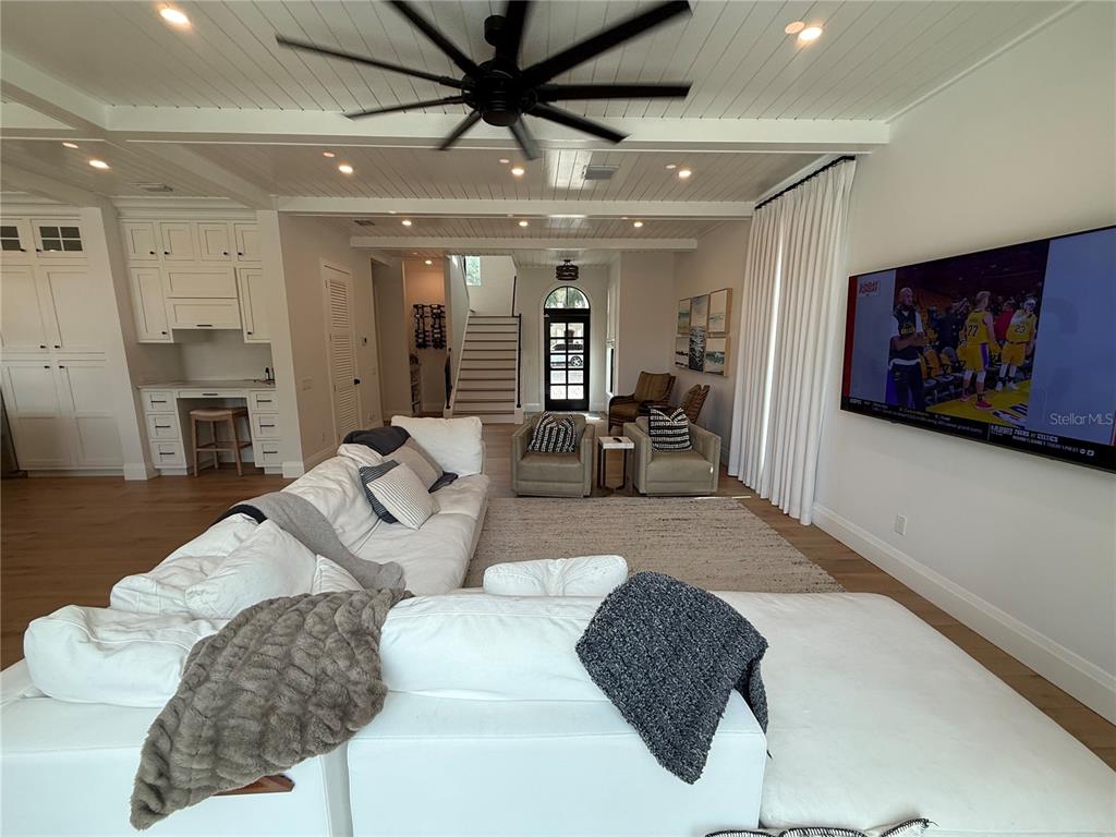 A kitchen features white upper cabinets, a blue island with a white countertop, and wood floors — 802 HAMILTON PLACE COURT, WINTER PARK, FL