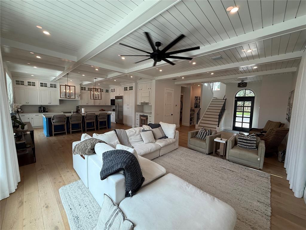 A spacious living room features a white sectional sofa, coffered ceiling, and light wood flooring — 802 HAMILTON PLACE COURT, WINTER PARK, FL