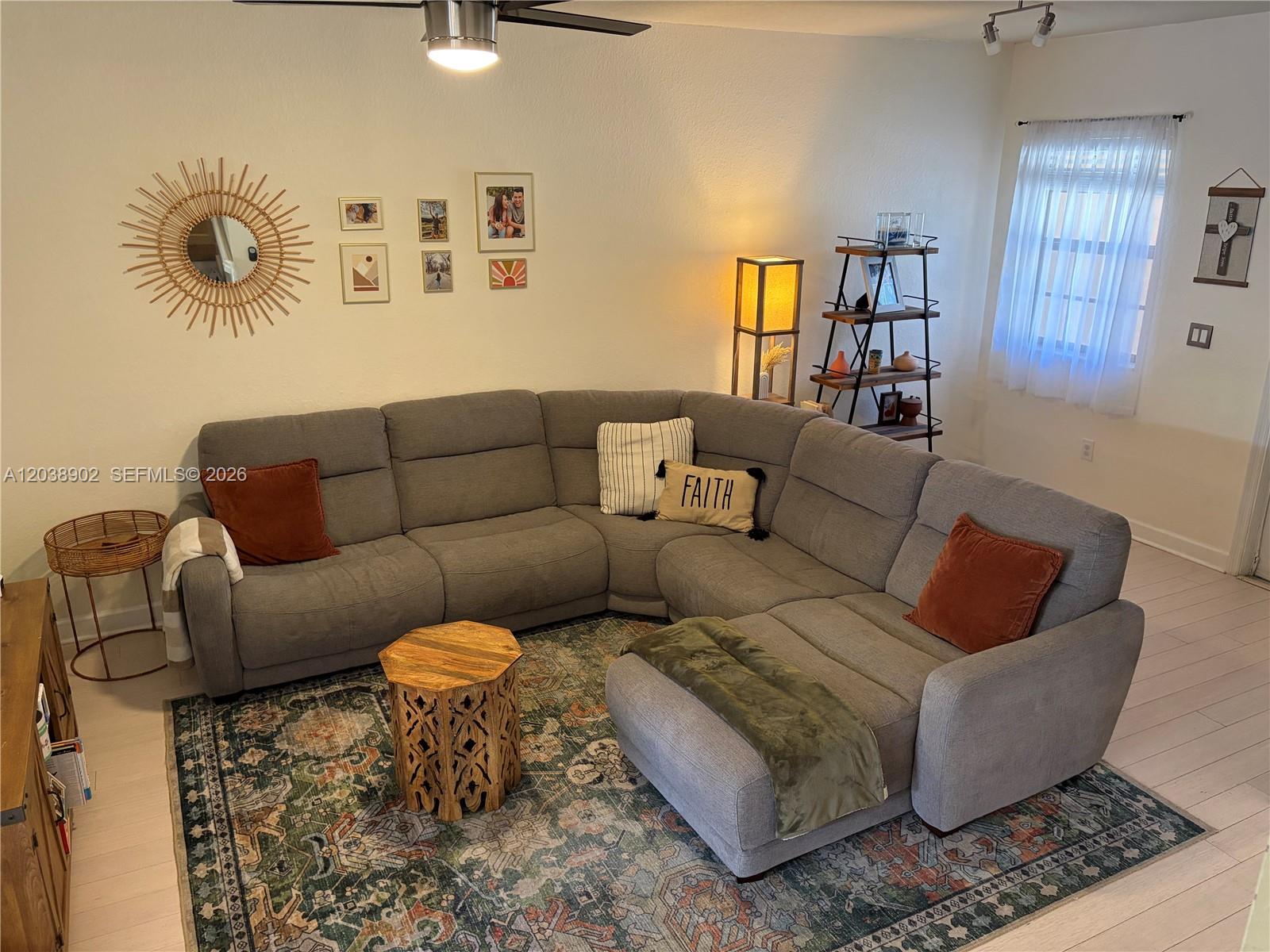 A living room features a large gray sectional sofa, a patterned rug, and wall decor — 370 NE 37th Pl, Homestead FL 33033, HOMESTEAD, FL