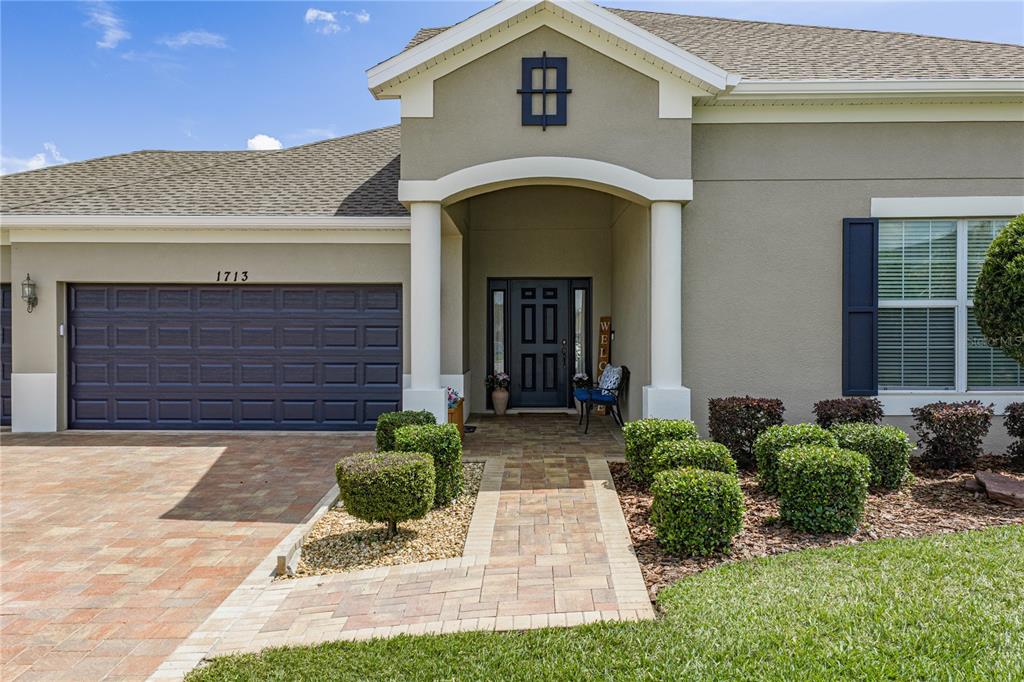 An entryway with a staircase, a dining room, and a kitchen visible through an archway — 1713 VIA PALERMO STREET, PLANT CITY, FL