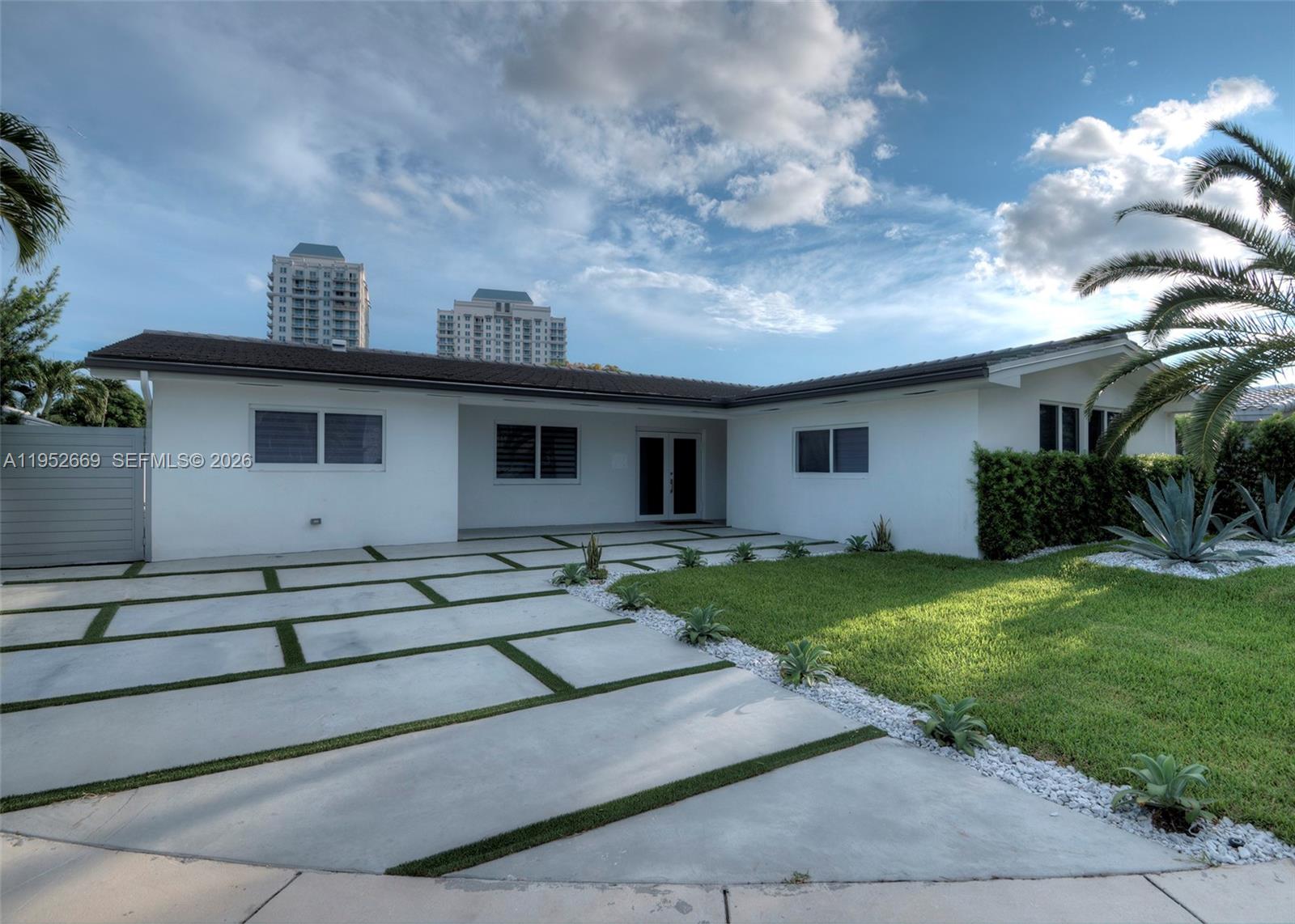 A white single-story house features a modern concrete paver driveway with grass inlays — 1250 NE 82nd St, Miami FL 33138, MIAMI, FL