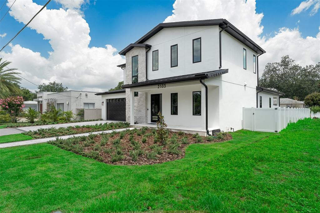 A modern kitchen features a large green island with bar seating and white countertops — 2103 GALE STREET, ORLANDO, FL