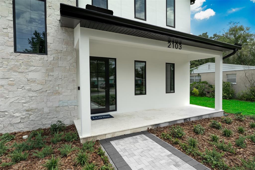 A backyard features a rectangular swimming pool, stone patio, outdoor kitchen, and bamboo landscaping — 2103 GALE STREET, ORLANDO, FL