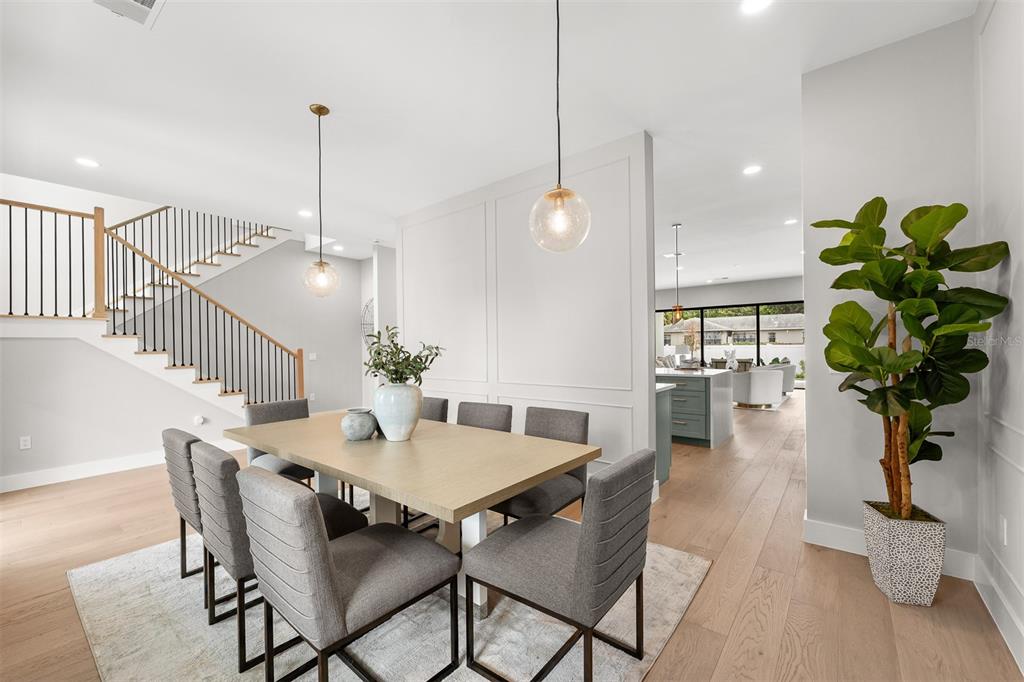 A modern kitchen features a sage green island, white countertops, and light wood flooring — 2103 GALE STREET, ORLANDO, FL